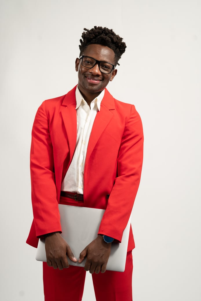 Smiling Man in Red Suit Holding a Laptop