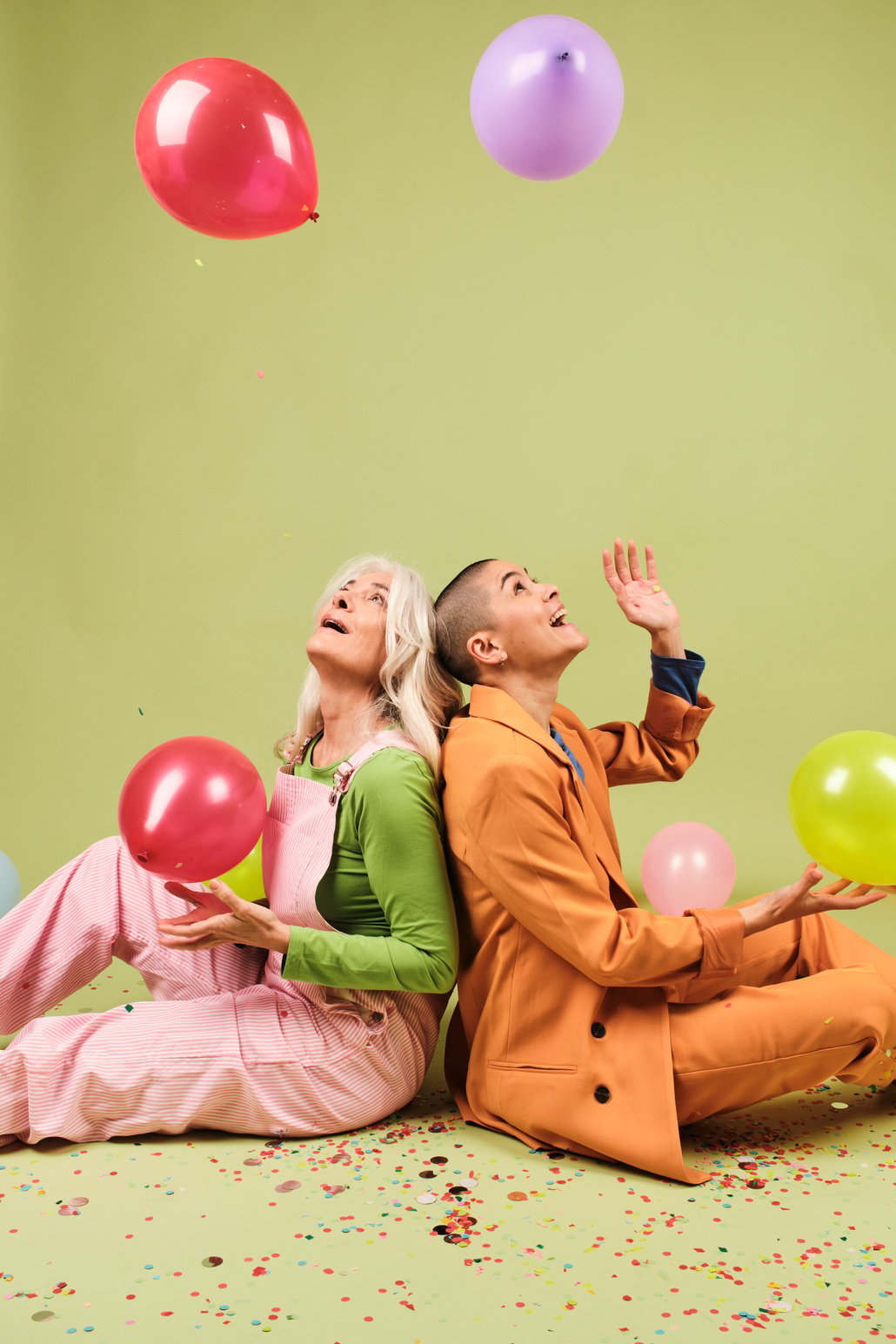 Playful Portrait of Two Creatives Playing with Balloons in Studio