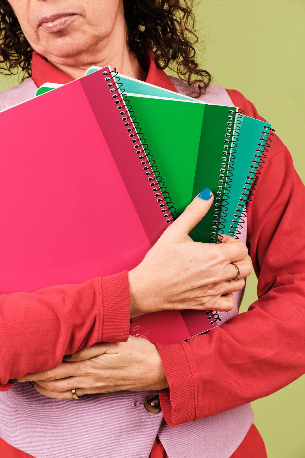 Closeup of Creative Holding Notebooks on Green Background