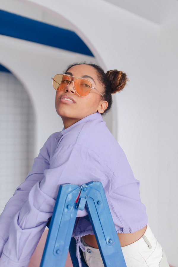 Young Girl in Sunglasses Leaning on a Ladder